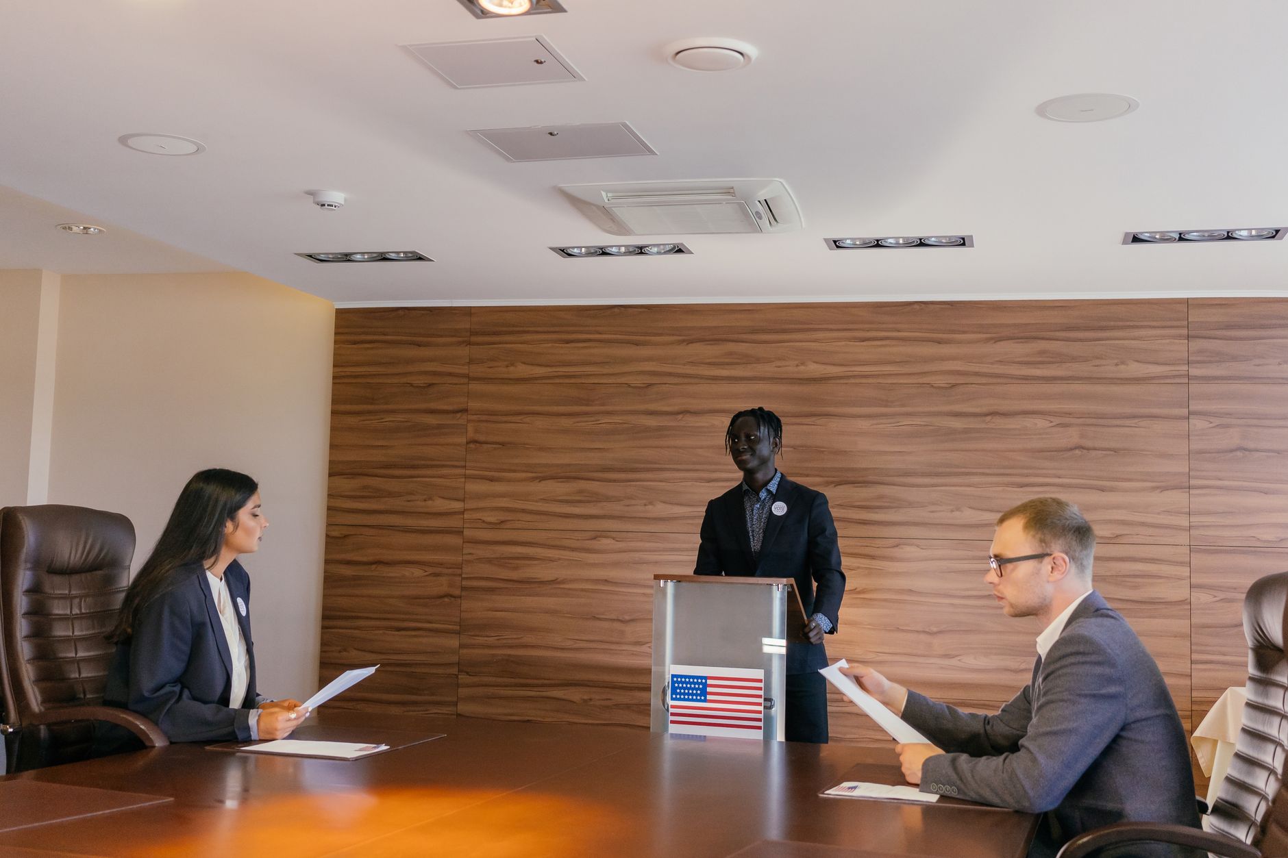 Business professionals engaged in a formal meeting, discussing key topics around a conference table