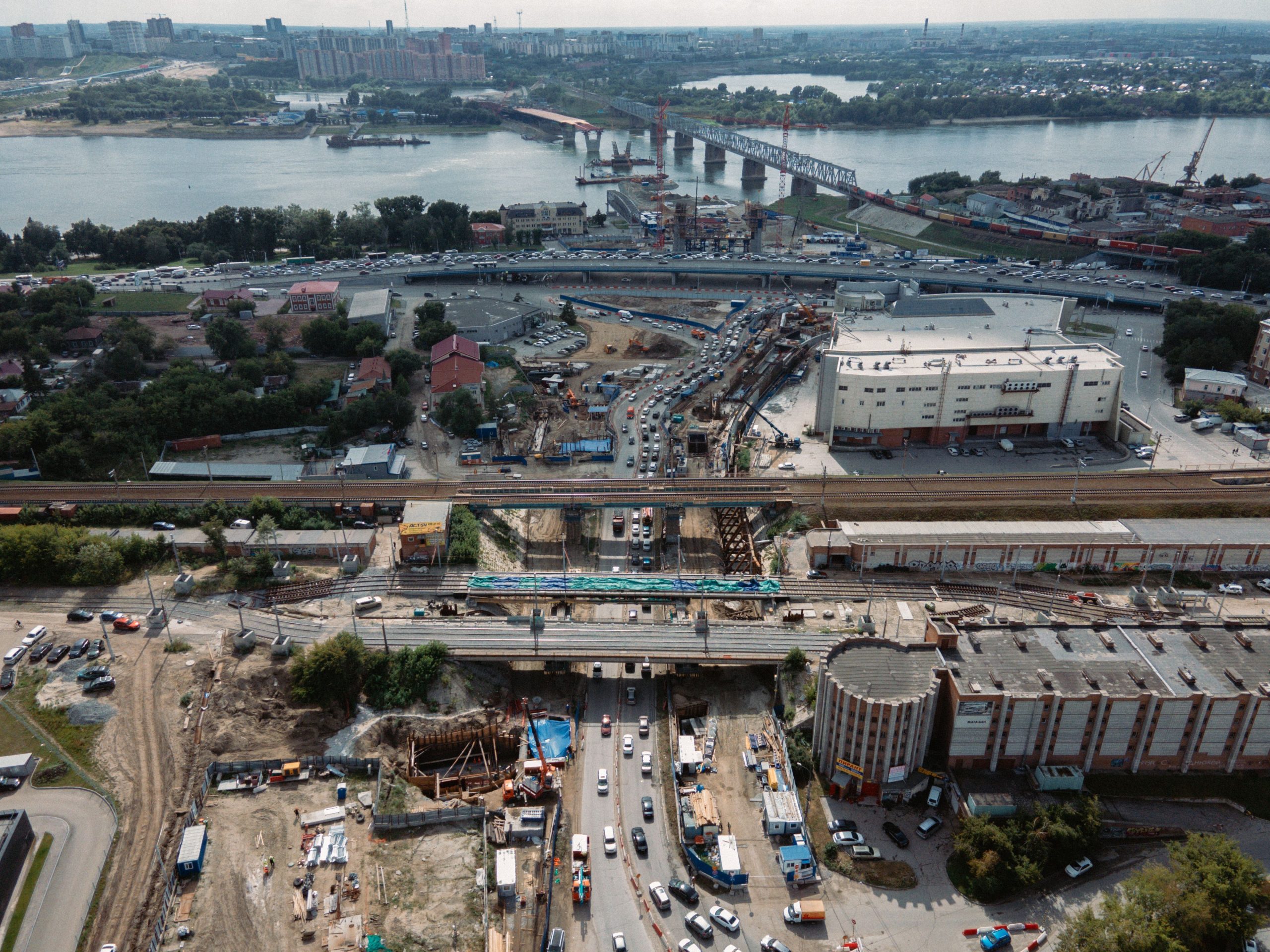 Aerial view of a road and bridge construction project beside a busy urban highway, the kind of work that relies on federal transportation funding.
