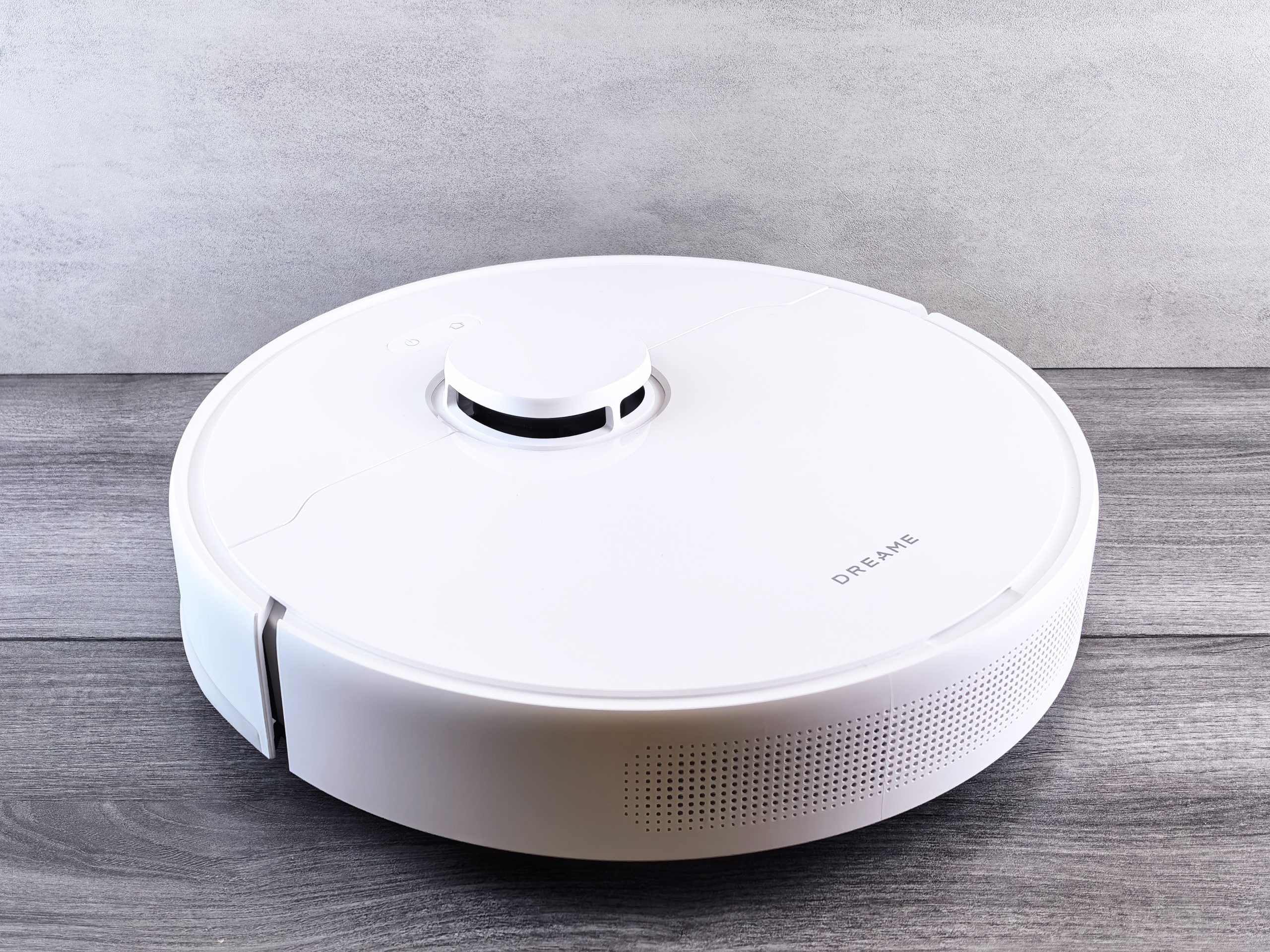 A white Dreame robot vacuum on a wood-patterned floor