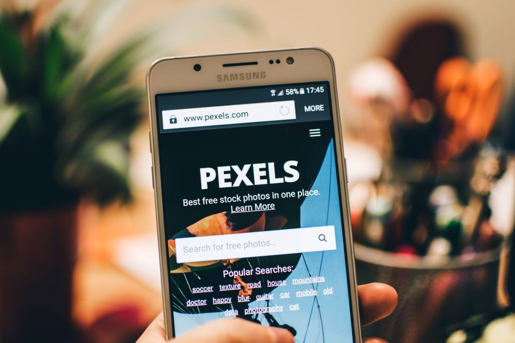 A close-up view of a smartphone displaying the Pexels website screen for stock photo searches
