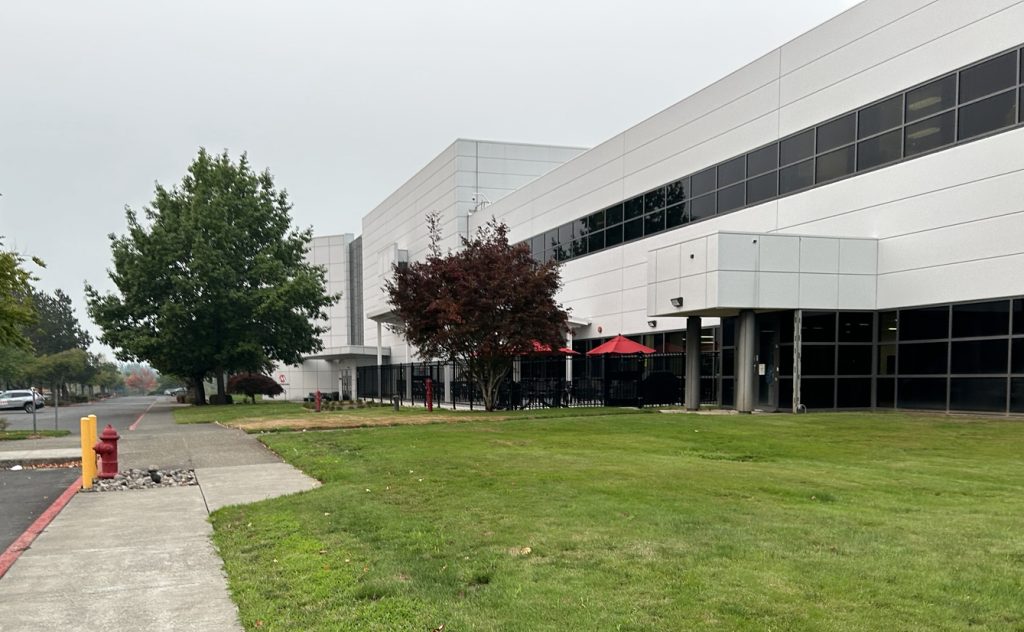 A semiconductor fabrication facility with a glass-front entrance and landscaped grounds