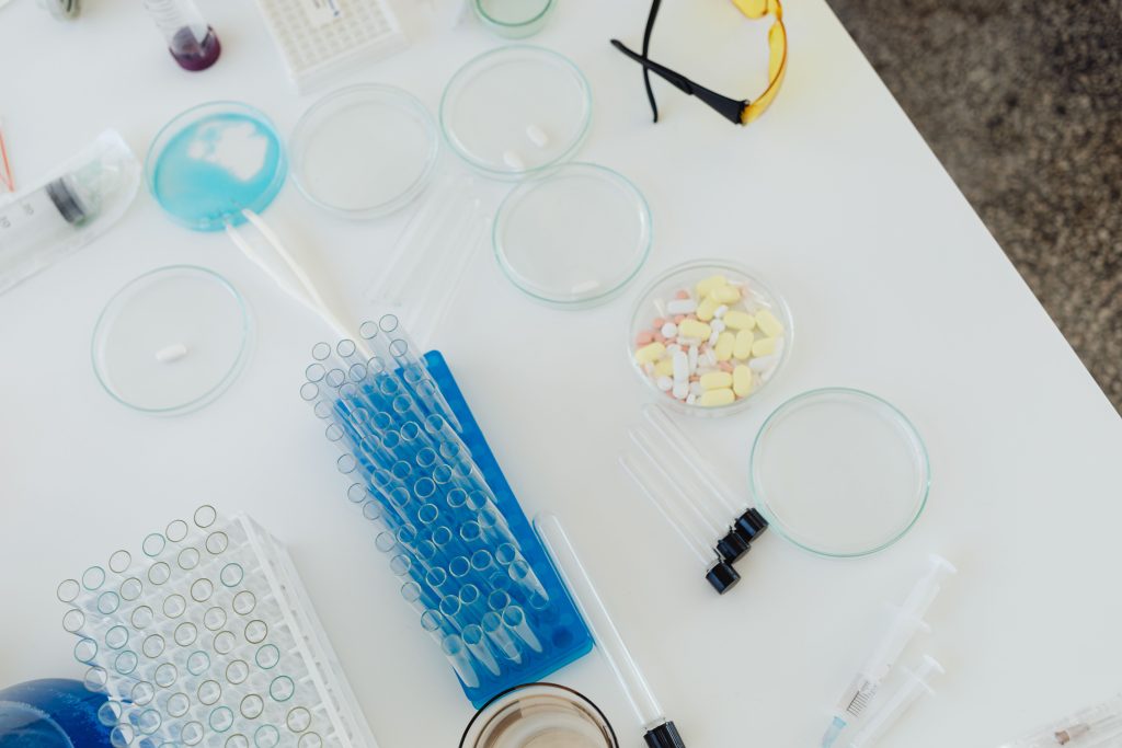 Test tubes, petri dishes and pills arranged on a laboratory table
