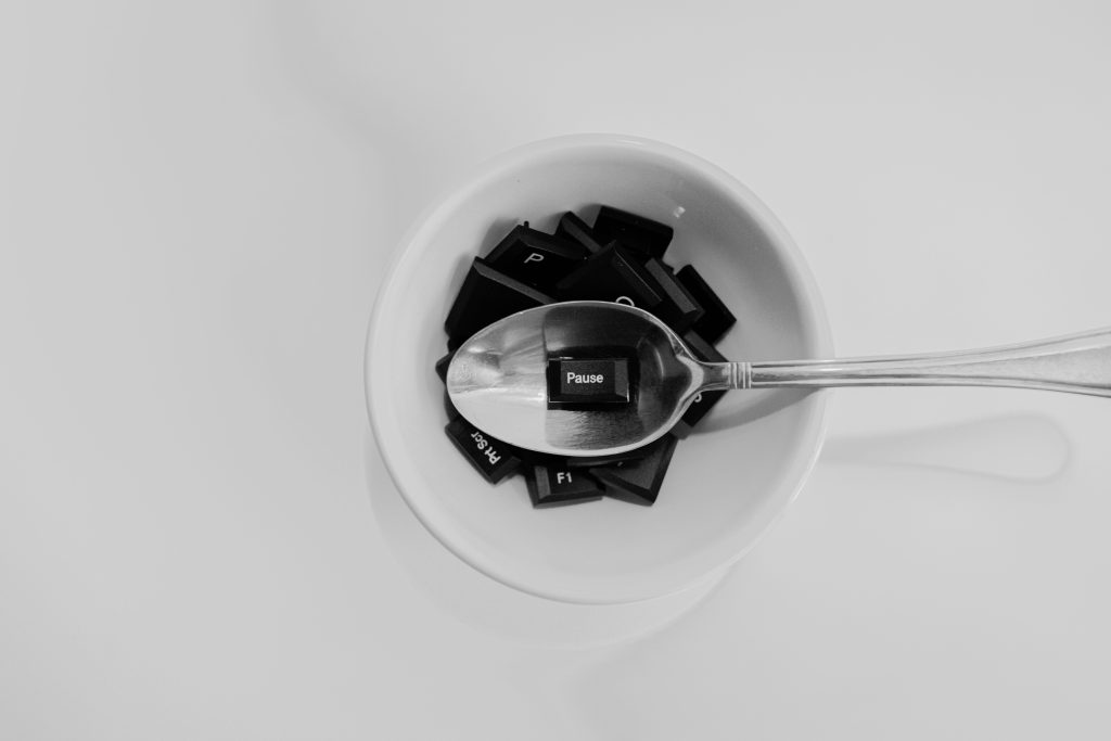 Unique black and white photo of keyboard keys in a bowl with a spoon featuring the 'Pause' key